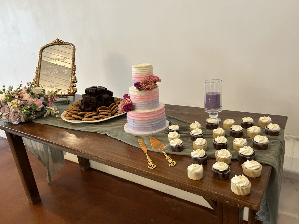 A wedding cake and desserts set up on a table.
What Does a DJ do? They help coordinate with other vendors, even the caterers and cake delivery, to ensure a seamless timeline.
